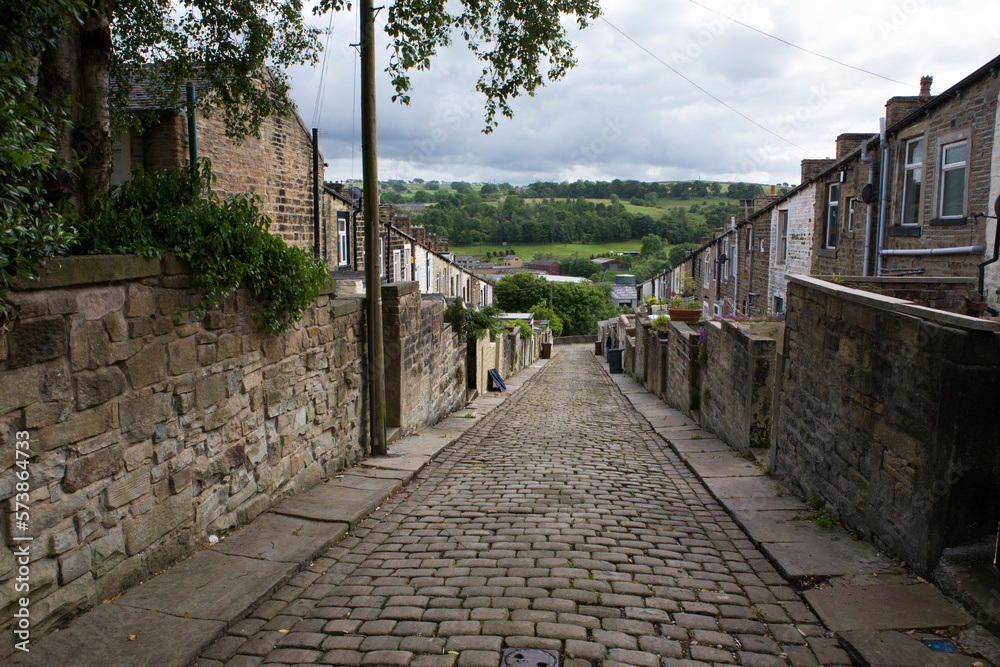 A steep terrace of traditional 19th century millworkers' cottages: back lane between Colne Lane and Basil Street, Colne, Lancashire, UK