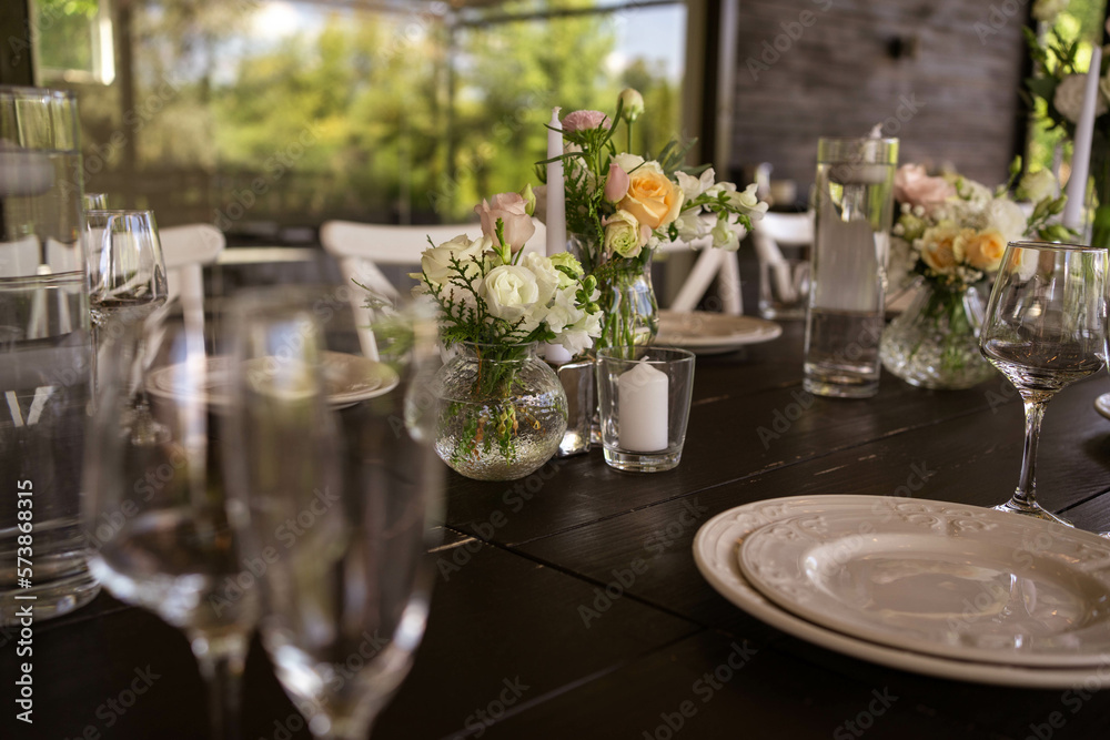 A very nicely decorated wedding table appointments with beautiful decor with plates and serviettes in spring garden. Beautiful flowers on table in wedding day. The elegant dinner table. A very nicely decorated wedding table appointments with beautiful decor with plates and serviettes in spring garden. Beautiful flowers on table in wedding day. The elegant dinner table.