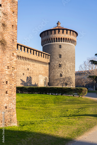 A fragment of the facade of the castle with tower at sunny day in Milan, Italy