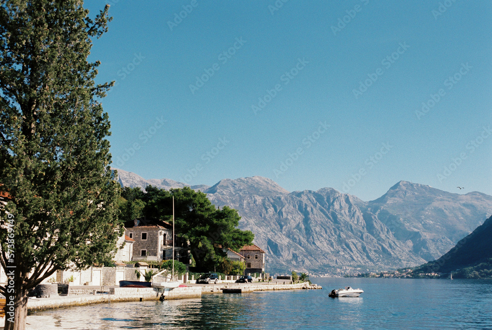 Stone houses on the shore of the bay against the backdrop of mountains. Montenegro