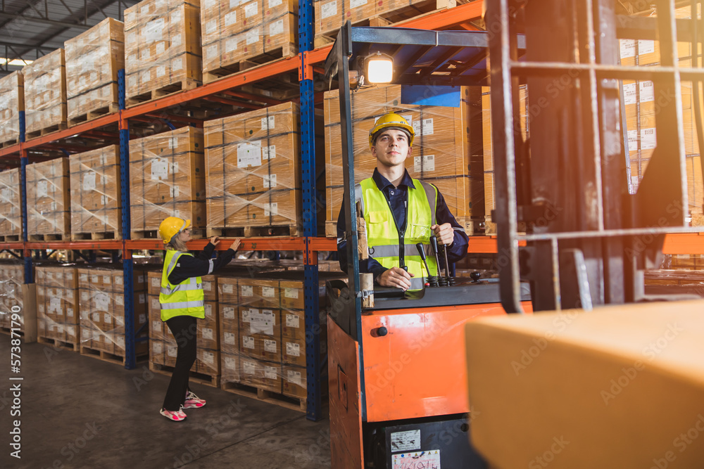 Caucasian male worker working in warehouse goods store. inventory staff moving producs pallet shipping management with forklift truck.