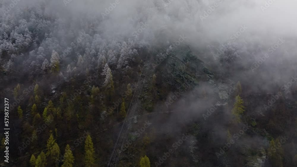 Relaxing drone video in Swiss Alps on cloudy moody grey winter afternoon with lush pine forests and beautiful snowy trees on mountains sideways flying and rotating Relaxing drone video in Swiss Alps on cloudy moody grey winter afternoon with lush pine forests and beautiful snowy trees on mountains sideways flying and rotating