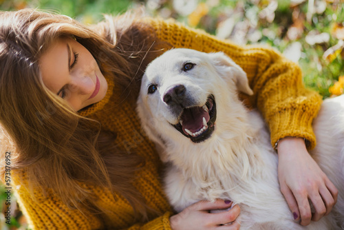 Belgrade, Serbia. November 10th, 2022. Young beautiful woman looking at her golden retriever and having fun in a park on a sunny day.