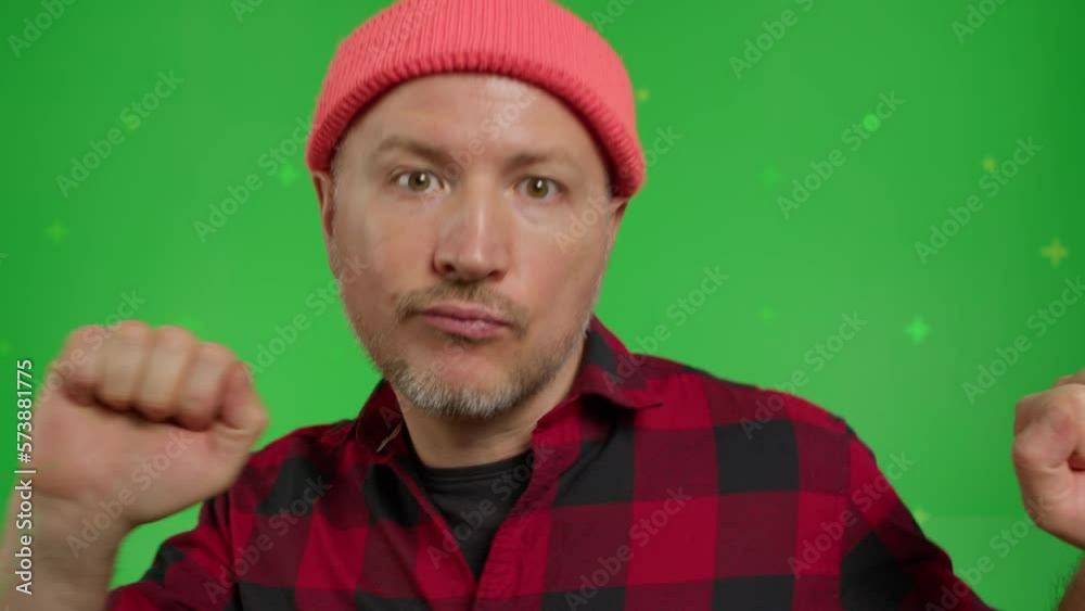Extreme close-up of a caucasian man in red shirt and beanie having fun dancing on a Green Screen, Chroma Key. Extreme close-up of a caucasian man in red shirt and beanie having fun dancing on a Green Screen, Chroma Key.