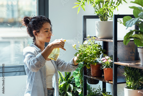 Bilde på lerret Beautiful smiling woman arranging plants and flowers in a greenhouse