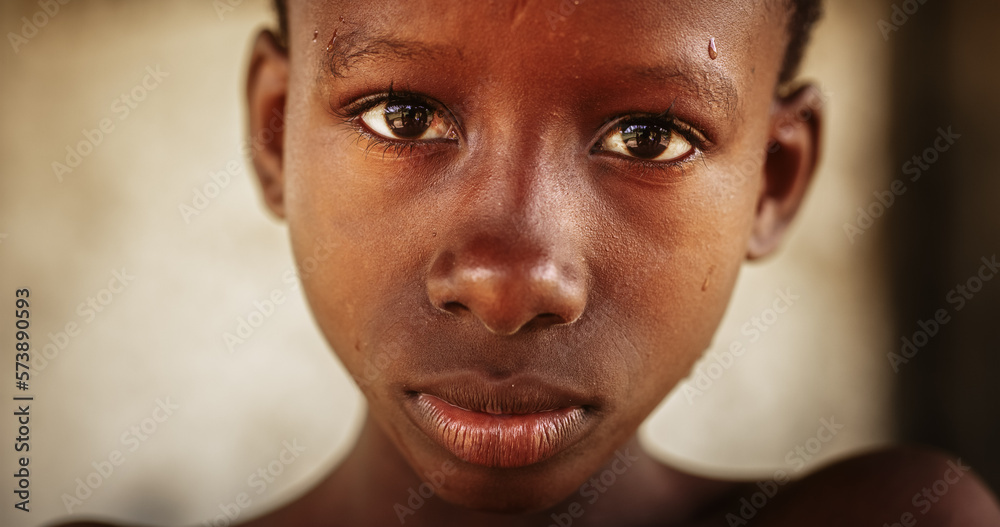 Extreme Close up Portrait of an Authentic African Boy Looking Seriously at the Camera then Cracking a Big Smile. Expressive Male Child Laughing and Sharing his Happiness with Others Extreme Close up Portrait of an Authentic African Boy Looking Seriously at the Camera then Cracking a Big Smile. Expressive Male Child Laughing and Sharing his Happiness with Others
