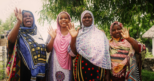 A Group of Authentic African Women in Traditional Clothes Waving and Smiling at the Camera. Friendly Female Rural Villagers Welcoming People in their Village with Big Smiles and Open Hearts photo