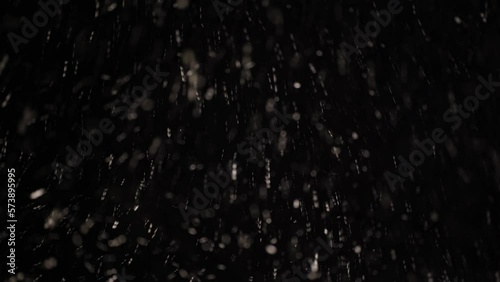Rain and snow falling in the dark sky of a winter night, sleet on black background photo