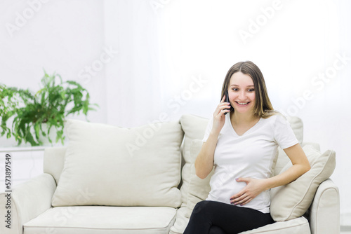 Photo of pregnant woman talking over the phone.