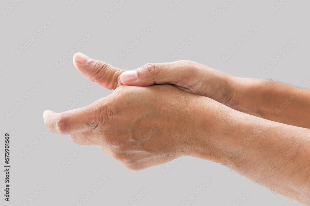 A man with thumb pain on a gray background.