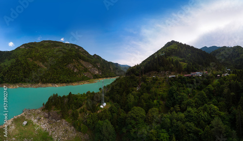 Aerial view Inguri reservoir lake in Upper Svaneti region, Georgia. Emerland water. Communication tower, metal structure. Power lines, wires and energy in hard-to-reach places. Travel and tourism