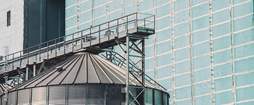 Agricultural silos. Storage and drying of grains, wheat, corn, soy, sunflower. Industrial building exterior. Big metallic silver containers close-up. Background of agricultural tanks with copy space.