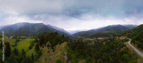 Summer mountain valley  beautifull road way to Mestia. Tsalanari  Hebudi  Georgia. Nature and car travel concept. Electrification in the mountains. Power grid tower. Wide panorama. Aerial view.