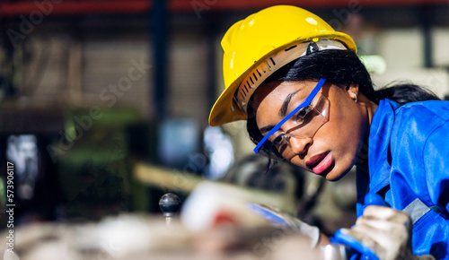 Professional labor machanic engineer technician worker industrial african black woman wearing blue safety uniform working control with heavy machine in manufacturing  factory production line.industry