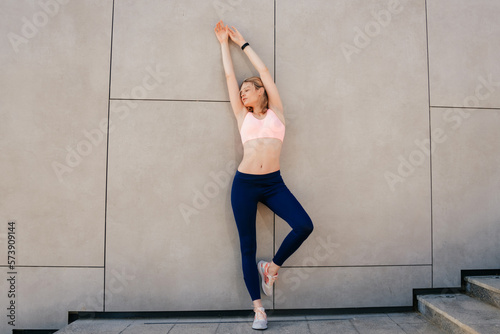 elegant sporty girl standing near the wall © Aleksandr