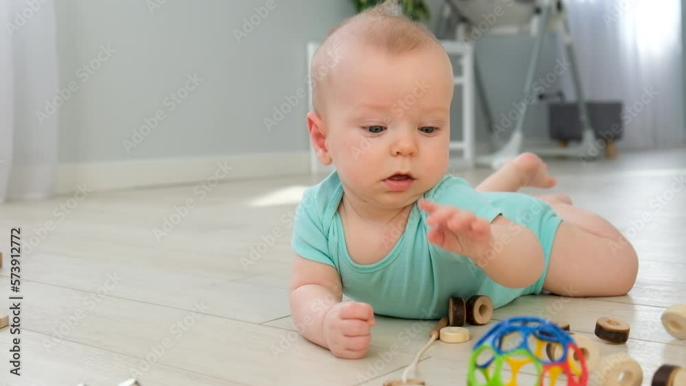 Baby rolling. Cute little baby rolling over on floor at home among toys. Infant leisure at home. Infant development skills. Baby rolling. Cute little baby rolling over on floor at home among toys. Infant leisure at home. Infant development skills.