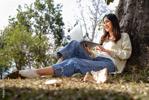 Asian girl chilling with using laptop at garden.