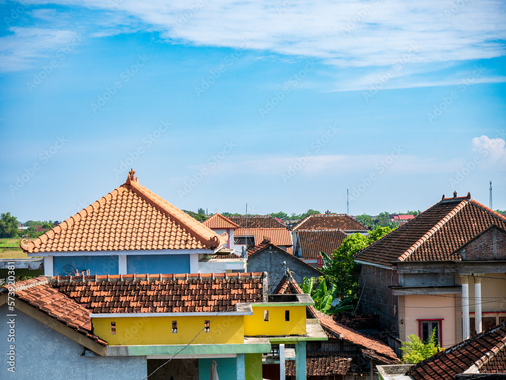 Captivating view from the third floor, showcasing beautiful rooftops and a mesmerizing blue sky adorned with gentle clouds Captivating view from the third floor, showcasing beautiful rooftops and a mesmerizing blue sky adorned with gentle clouds