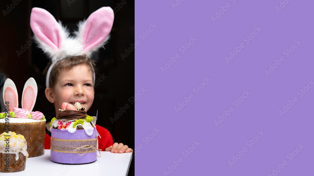 Cute little boy with bunny ears looking at tasty easter sweet cake