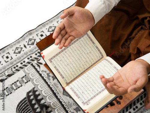 Men pray with backdrop of Quran