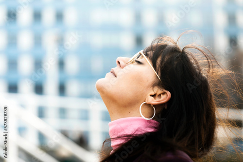 фотографія Profile portrait of woman with eyes closed breathing deeply in clean city air