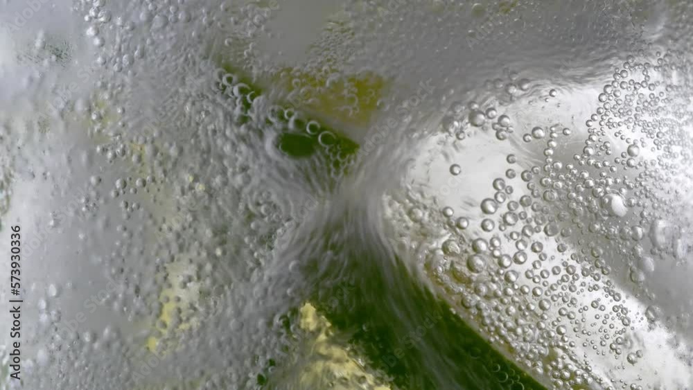 Cold lemonade mojito cocktail carbonated drink. Closeup refreshing soda tonic fizzy sparkling water, mint and lemon in glass, ice cubes. Slice of lemon, mineral bubbles. Healthy dietary nutrition.