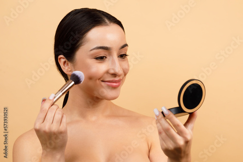 Beautiful Indian Female Holding Compact Powder And Applying On Face With Brush