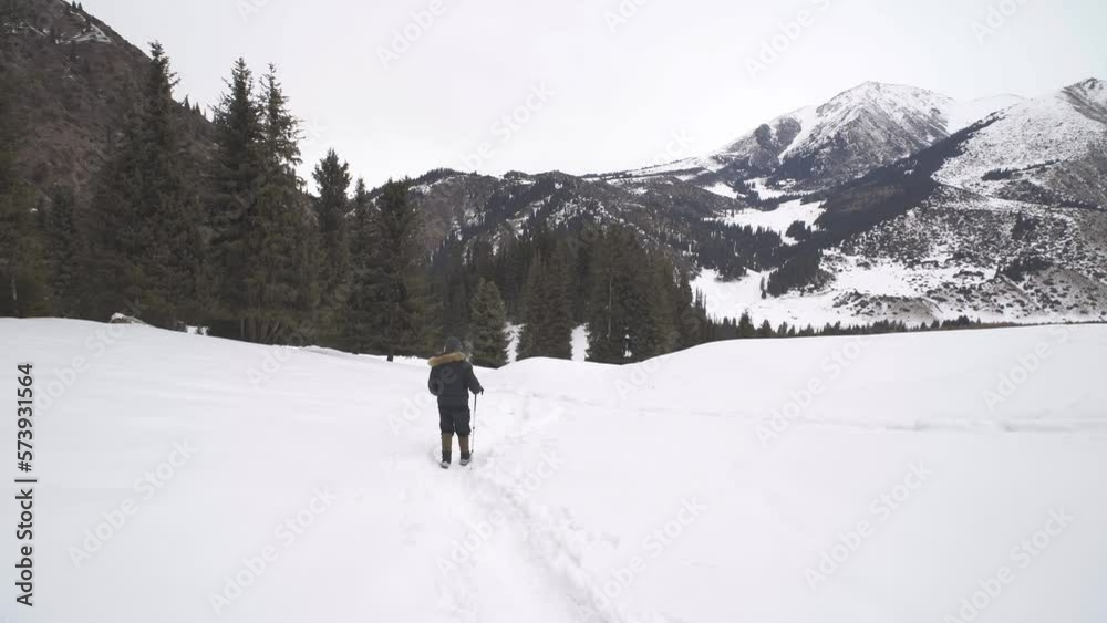 Mountain tourists go down the slope of Kok-Zhaiyk plateau. Winter season Mountain tourists go down the slope of Kok-Zhaiyk plateau. Winter season