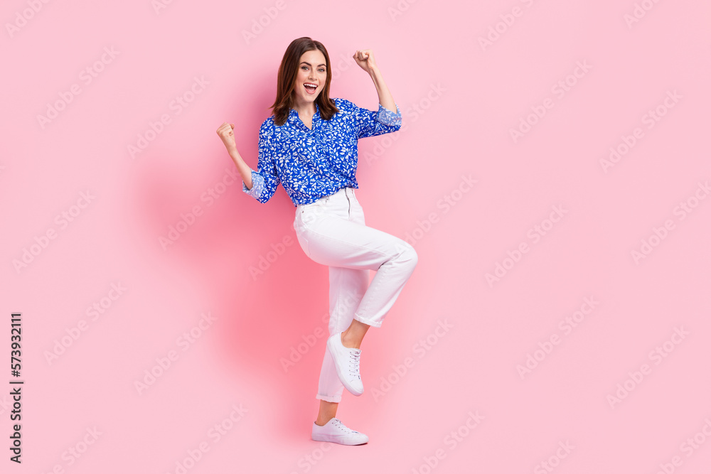 Full length photo of lucky funky lady wear print shirt rising fists empty space isolated pink color background Full length photo of lucky funky lady wear print shirt rising fists empty space isolated pink color background