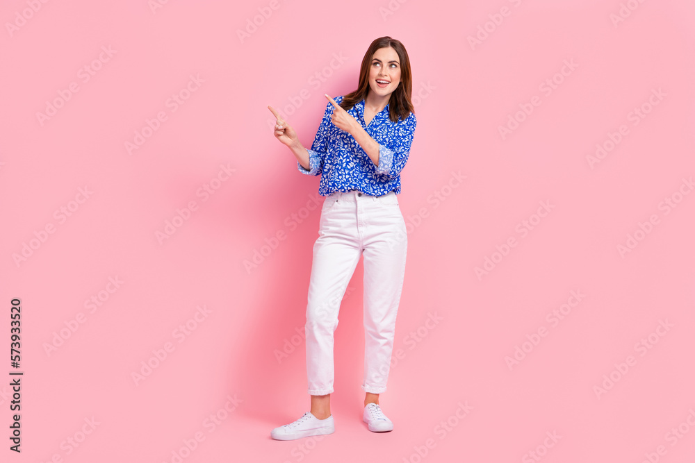 Full length photo of adorable excited lady wear print shirt showing looking empty space isolated pink color background Full length photo of adorable excited lady wear print shirt showing looking empty space isolated pink color background