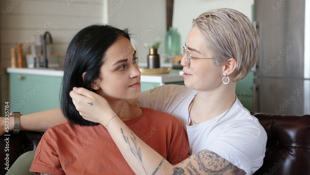 Young woman in glasses hugs smiling girlfriend at home Young woman in glasses hugs smiling girlfriend at home
