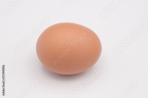 One chicken egg against a white background