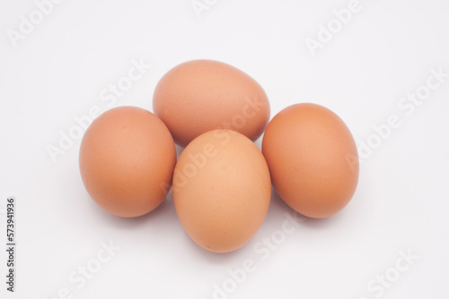 Four chicken eggs against a white background