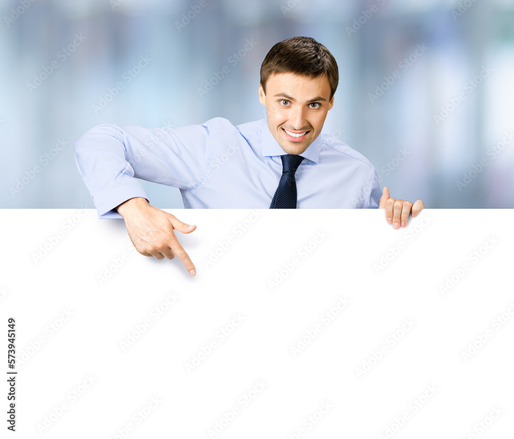 Portrait image of business man professional bank manager in confident cloth. Businessman stand behind, hang over, show point finger empty white banner signboard. Blurred office background Portrait image of business man professional bank manager in confident cloth. Businessman stand behind, hang over, show point finger empty white banner signboard. Blurred office background
