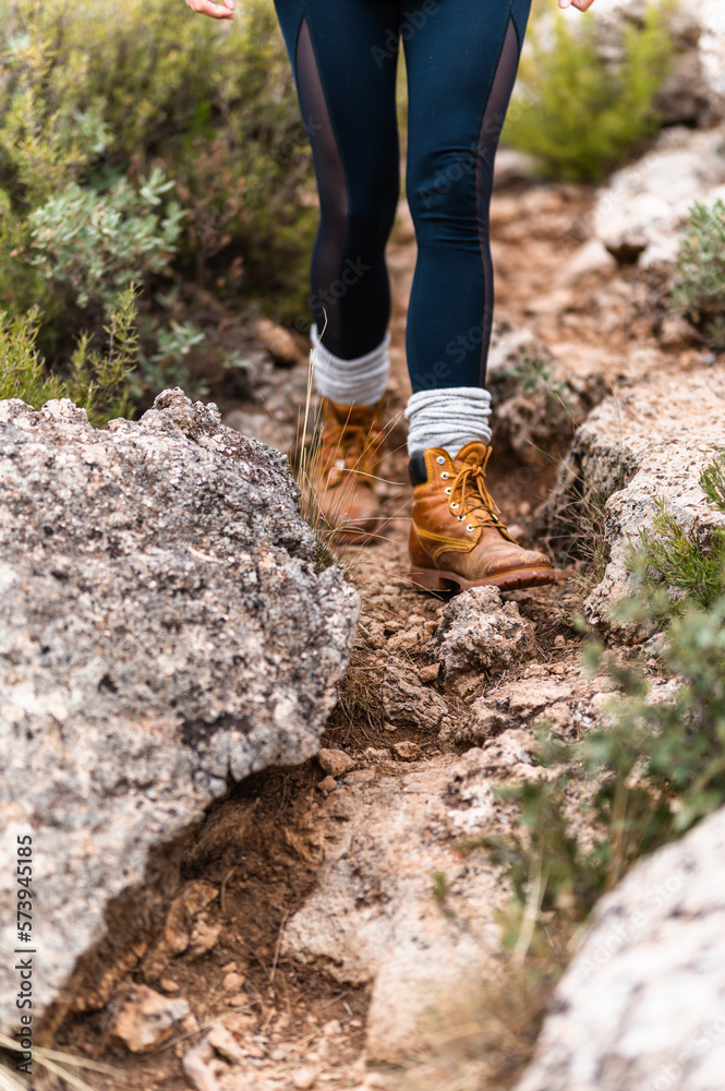 Crop person in boots walking on stone ground Crop person in boots walking on stone ground