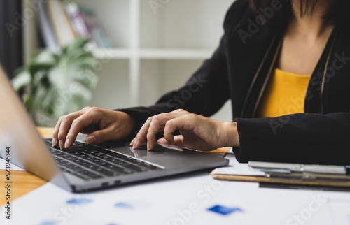 Businesswoman analyzing financial statistics displayed on the laptop screen, working data document graph chart report marketing research development planning management strategy accounting.