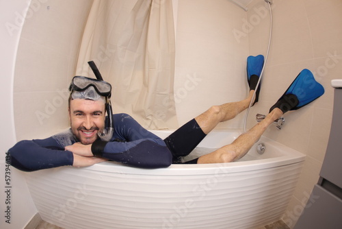 Humorous man snorkeling in the bathtub 