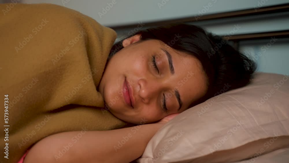 Happy young girl sleeping comfortably on bed at night - concept of wellness, healthy lifestyle and imagination. Happy young girl sleeping comfortably on bed at night - concept of wellness, healthy lifestyle and imagination.