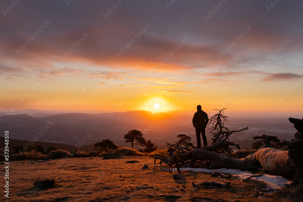 Person on the mountain contemplating the sunrise