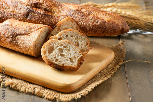 Home made sliced baguette bread on wood background, bread and bakery