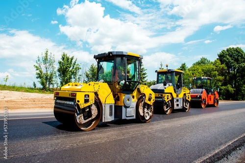 Obraz na płótnie industrial landscape with rollers that rolls a new asphalt in the roadway. Repair, complicated transport movement. w salonie