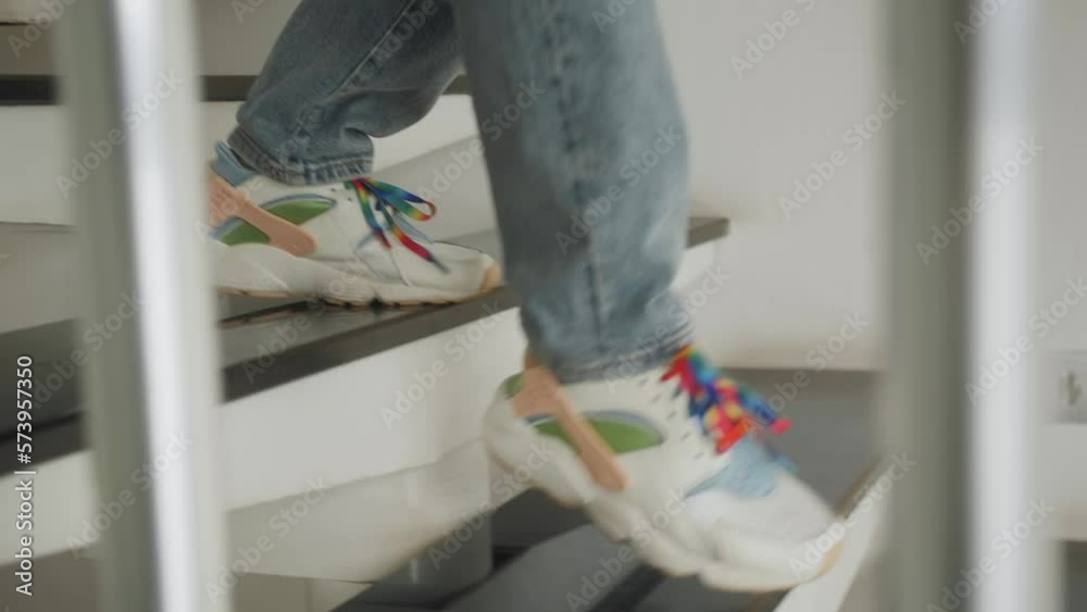 Teen girl in casual clothes goes down stairs. Close up of legs stepping down stairs. Teen girl in casual clothes goes down stairs. Close up of legs stepping down stairs.