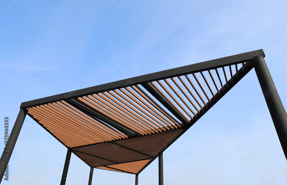 Wooden slats roof with blue sky background. Wooden slat shading