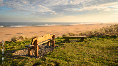 Fototapeta Naklejka Na Ścianę i Meble -  Bench overlooking Druridge Bay, located on the North Sea in Northumberland's AONB in England, it is a 7 miles long bay between Amble and Cresswell