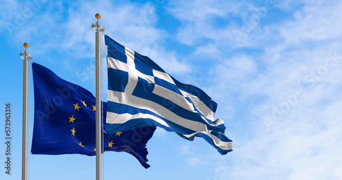 The flags of Greece and the European Union waving together on a clear day