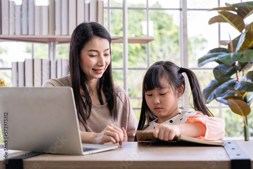 Home schooling learning at home. asian woman with her daughter in the living room