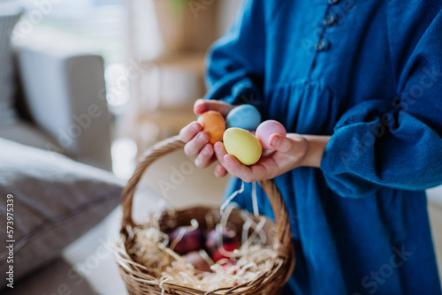 Close-up of little girl holding basket with easter eggs.