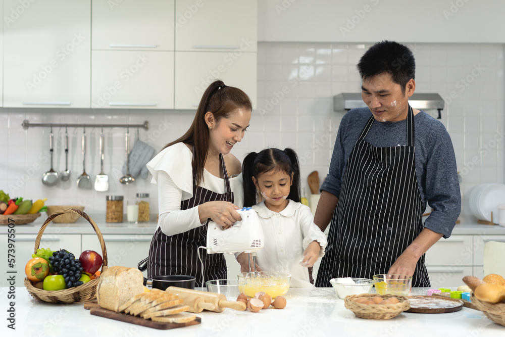 Happy asia family with daughter making dough preparing baking cookies, Daughter help parent preparing the bake Family concept