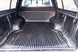 The body space of the trunk of a car in the back of a pickup truck for transporting goods like on a truck.
