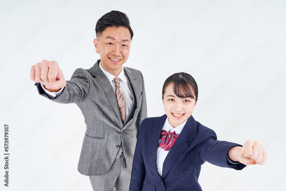 ガッツポーズをするスーツ姿の男性と女子高生 ガッツポーズをするスーツ姿の男性と女子高生